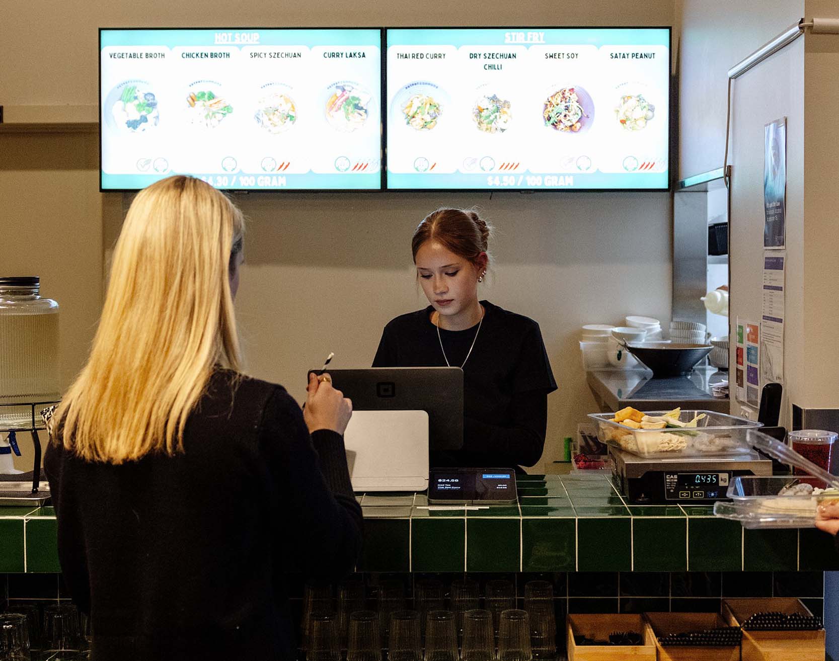 Team members plating hotpot ingredients in the kitchen.